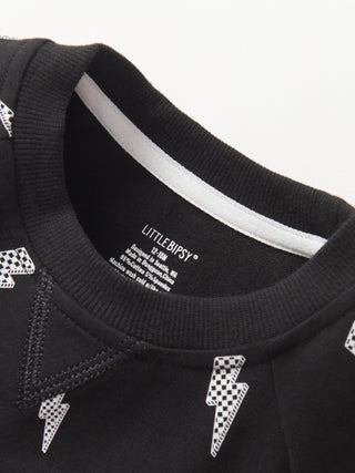 Little Bipsy Lightning Bolt Pullover - Black
Close-up of a black garment with white accents and 'Little Bipsy' branding.