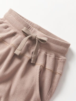 Little Bipsy Ribbed Jogger - Mushroom
Beige sweatpants with a drawstring on a light gray background