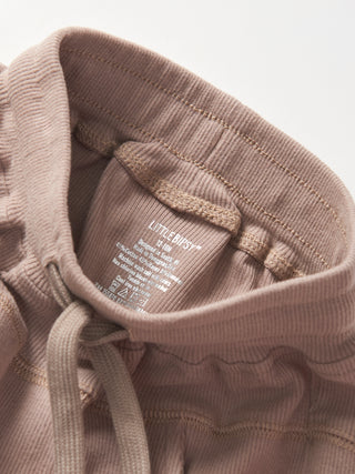 Little Bipsy Ribbed Jogger - Mushroom
Close-up of a brown corduroy jacket with a label on a light gray background