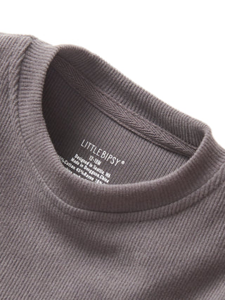 Little Bipsy Long Sleeve Ribbed Tee - Graphite
Close-up of a gray sweater with 'Little Bipsy' label on a white background