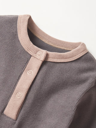 Little Bipsy Colorblock Ribbed Romper - Graphite
Close-up of a gray baby outfit with a beige collar and buttons on a light gray background