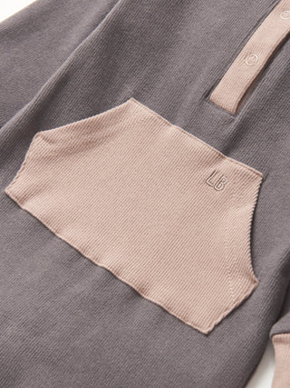 Little Bipsy Colorblock Ribbed Romper - Graphite
Close-up of a gray shirt with a beige pocket and brand logo.