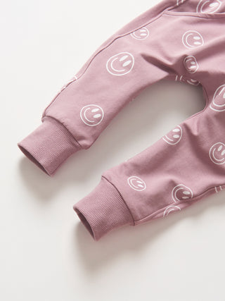 Little Bipsy Smiley Jogger - Dusty Purple
Pink baby pants with smiley face patterns on a white background