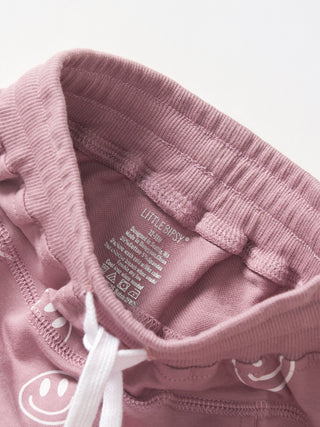 Little Bipsy Smiley Jogger - Dusty Purple
Close-up of a pink hoodie with a brand label on a light gray background