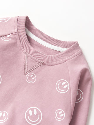 Little Bipsy Smiley Pullover - Dusty Purple
Pink sweatshirt with smiley face patterns on a white background