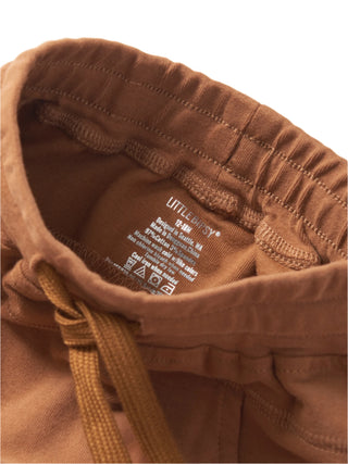 Little Bipsy Jogger - Chestnut 
Close-up of brown corduroy pants with a label on a white background