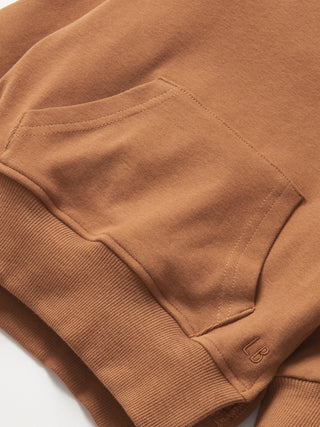 Little Bipsy Pocket Pullover - Chestnut Close-up of a brown sweatshirt pocket with a brand logo on a white background