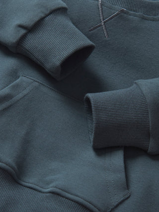 Little Bipsy Pocket Pullover - Night Fall 
Close-up of a dark gray sweatshirt with a focus on the sleeves and collar.