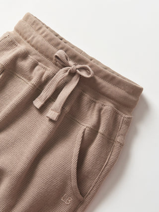 Little Bipsy Waffle Jogger - Mushroom
Brown waffle knit pants with a drawstring on a white background