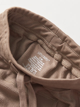 Little Bipsy Waffle Jogger - Mushroom
Close-up of a brown garment with a label on a light gray background