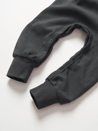 Little Bipsy Waffle Romper - Shadow
Dark gray ribbed knit garment on a white background