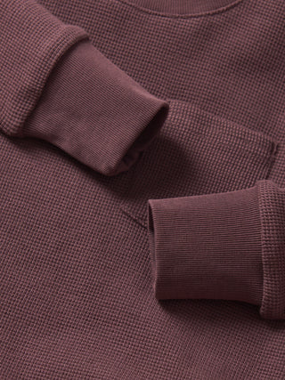 Little Bipsy Waffle Top - Huckleberry
Close-up of a brown textured sweater with rolled-up sleeves.