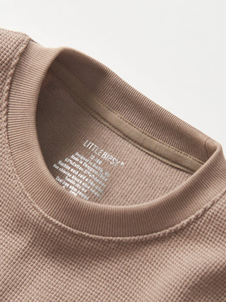 Little Bipsy Waffle Top - Mushroom
Close-up of a beige sweater with 'Little Bipsy' label on a light gray background
