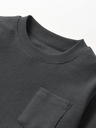 Little Bipsy Waffle Top - Shadow
Close-up of a dark gray textured shirt with a pocket on a white background