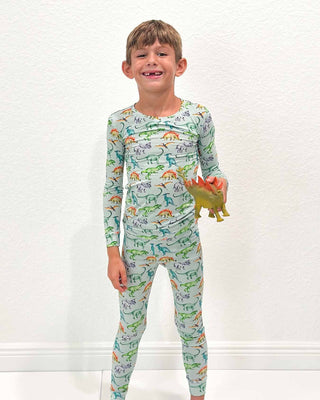 Lev Baby Pajama Set - Landon
Child wearing a dinosaur-themed pajama set holding a toy on a white background