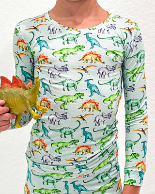 Lev Baby Pajama Set - Landon
Person wearing a shirt with colorful dinosaur pattern holding a toy dinosaur.
