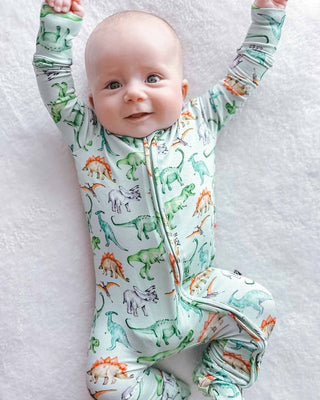 Lev Baby Zippered Footie - Landon
Baby wearing a dinosaur-patterned onesie on a white blanket