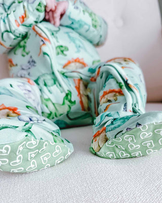 Lev Baby Zippered Footie - Landon
Baby in a dinosaur-themed outfit sitting on a light-colored surface