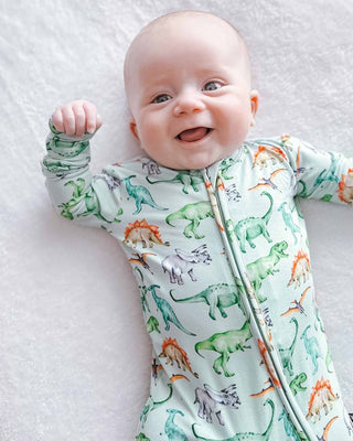 Lev Baby Zippered Footie - Landon
Baby wearing a dinosaur-patterned onesie on a white blanket