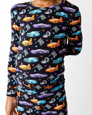 Lev Baby Pajama Set - Elias 
Children's long-sleeve shirt with car and racing pattern on a black background