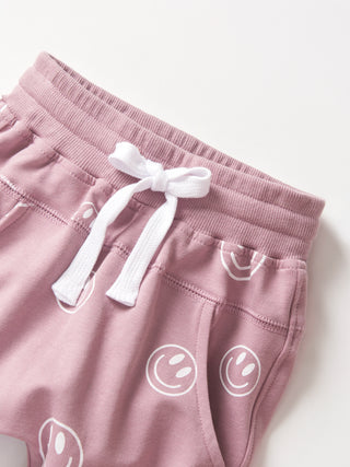 Little Bipsy Smiley Jogger - Dusty Purple
Pink shorts with white smiley face patterns and a white drawstring on a light gray background