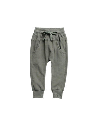 Little Bipsy Waffle Joggers - Green
A pair of toddler jogger pants in olive green, featuring an elastic waistband with a drawstring, side pockets, and ribbed ankle cuffs, shown flat on a white background.