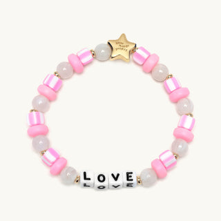 Little Words Project Bracelet - Kids: Love
A beaded bracelet with alternating pink and translucent white beads, a gold star charm engraved with 'Little Hands Jewelry', and white letter beads spelling 'LOVE' with black lettering, shown on a light cream background.