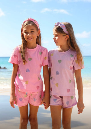 Lola and The Boys Crystal Hearts Short Set - Lavender
Two young girls in matching pink outfits with heart patterns standing on a beach.