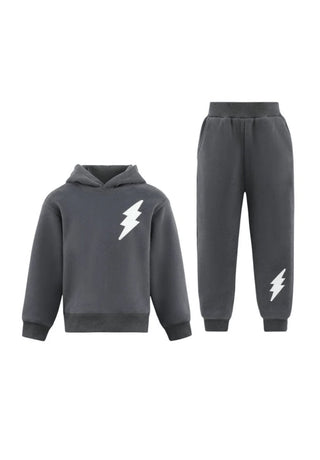 Lola and The Boys Lighting Flash Set - Grey
A dark gray two-piece kids' sweatshirt and jogger pants set, featuring a white lightning bolt graphic on the chest of the hoodie and on the lower leg of the pants, displayed against a solid white background.