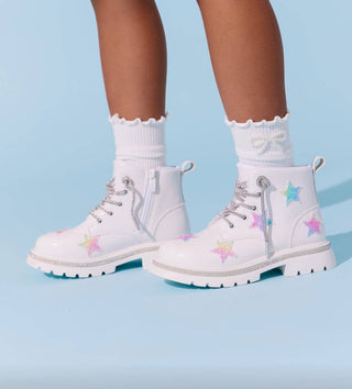 Lola and The Boys Rainbow Shimmer Stars Boots
White lace-up combat boots with pastel star patches, shown on a child's feet with white ruffled socks against a light blue background.
