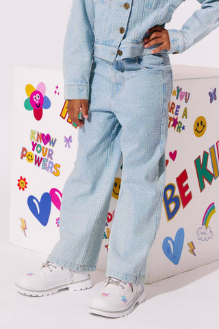 Lola and The Boys Sparkle Crystal Denim Jeans
A child wearing a light blue denim jacket and matching wide-leg jeans, paired with white sneakers, standing in front of a white display box decorated with colorful stickers and positive phrases.