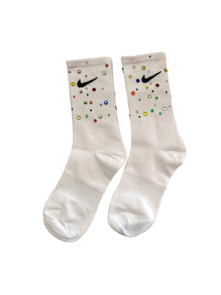 Lola and the Boys Gem Athletic Socks - White
A pair of off-white crew socks decorated with colorful rhinestones and a black Nike swoosh logo on the upper cuff, shown against a plain white background.