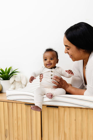 Lou Lou and Company Top and Bottoms - Winnie
Woman holding a baby on a wooden surface with a white background