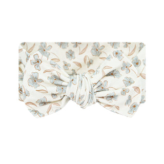 Lou Lou and Company Headband - Faye
A fabric headband with a knotted bow center, featuring a delicate floral pattern in light blue and brown on a warm cream background.