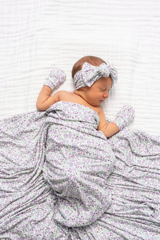 Lou Lou and Company Headband - Lily
Newborn baby wrapped in a floral blanket with matching headband and gloves on a white background