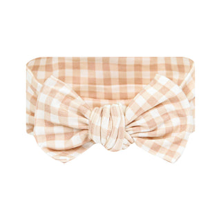 Lou Lou and Company Headband - Milo
A fabric headband with a large front bow, featuring a soft peach and white gingham check pattern, shown against a plain white background.