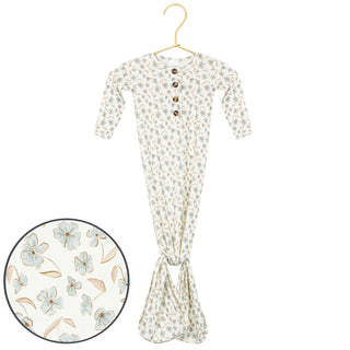 Lou Lou and Company Knotted Gown - Faye
A baby long-sleeve footed sleeper with a small floral print, hanging on a gold hanger against a white background, with a circular inset showing a close-up of the fabric pattern.