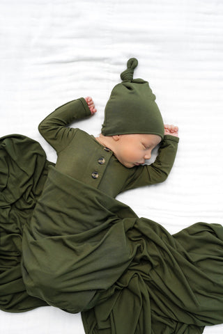 Lou Lou and Company Knotted Gown - Riley
Baby in an olive green outfit with a matching hat on a white background
