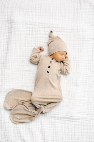 Lou Lou and Company Knotted Gown - Ryan
Newborn baby in a beige outfit and hat lying on a white textured blanket