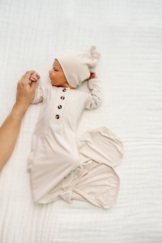 Lou Lou and Company Knotted Gown - Winnie
Newborn baby wrapped in a white swaddle with a matching hat on a white background