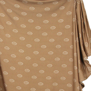 Lou Lou and Company Swaddle Blanket - Brady
A close-up of a draped brown fabric with a repeating pattern of small white oval motifs, showing the texture and drape of the material.