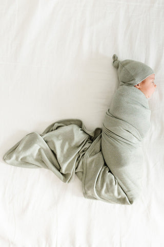 Lou Lou and Company Swaddle Blanket - Collins
Newborn baby wrapped in a green swaddle and cap on a white background