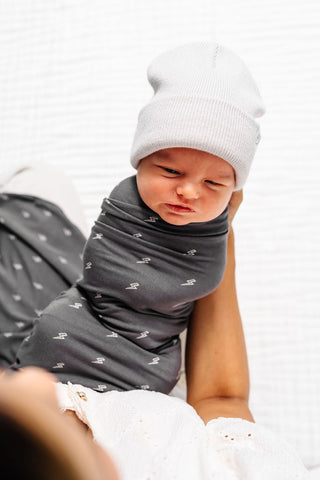 Lou Lou and Company Swaddle Blanket - Everett
Newborn baby swaddled in a gray blanket with a white hat on a white background