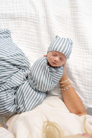 Lou Lou and Company Swaddle Blanket - Tatum
Newborn baby wrapped in a blue and white striped swaddle with matching hat, lying on a white textured surface.