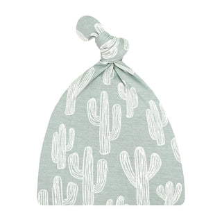 Lou Lou and Company Top Knot Hat - Knox
A sage green baby hat with a white cactus pattern, featuring a knotted top detail, shown against a plain white background.