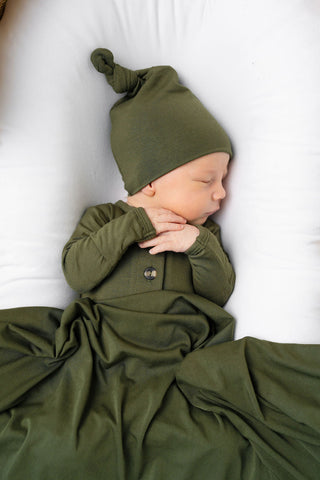 Lou Lou and Company Top Knot Hat - Riley
Newborn baby wearing a green outfit and hat on a white background