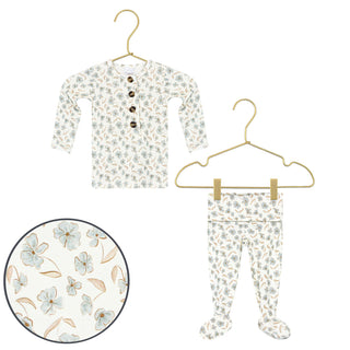 Lou Lou and Company Top and Bottoms - Faye
Baby long-sleeve footed pajama set with a floral print, featuring a henley top with buttons and matching pants, shown on hangers with a circular detail inset of the fabric pattern.