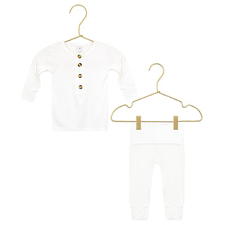 Lou Lou and Company Top and Bottoms - Finley
White baby outfit with gold buttons on a hanger against a white background