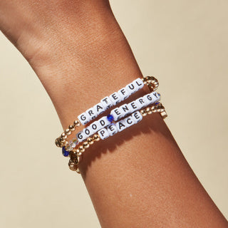Little Words Project Bracelet - Good Energy: Lucky Symbols
Bracelets with motivational phrases on a wrist against a beige background