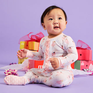 Magnetic Me Modal Footie with Ruffle - Pretty Plies
Baby in a patterned outfit sitting on a purple floor with colorful gift boxes in the background